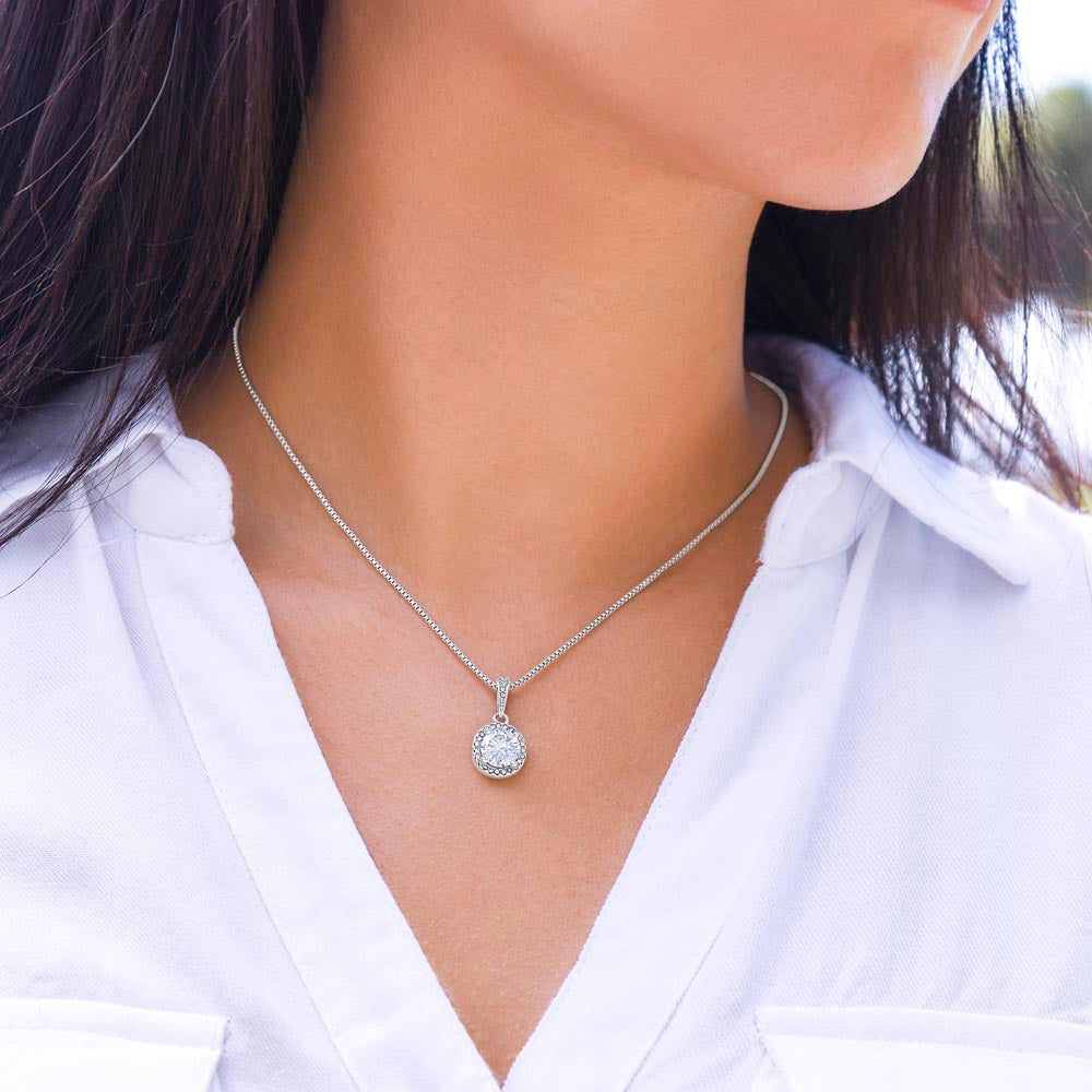 Woman wearing the Eternal Hope Necklace by Nori Kaelo, round halo pendant in white gold