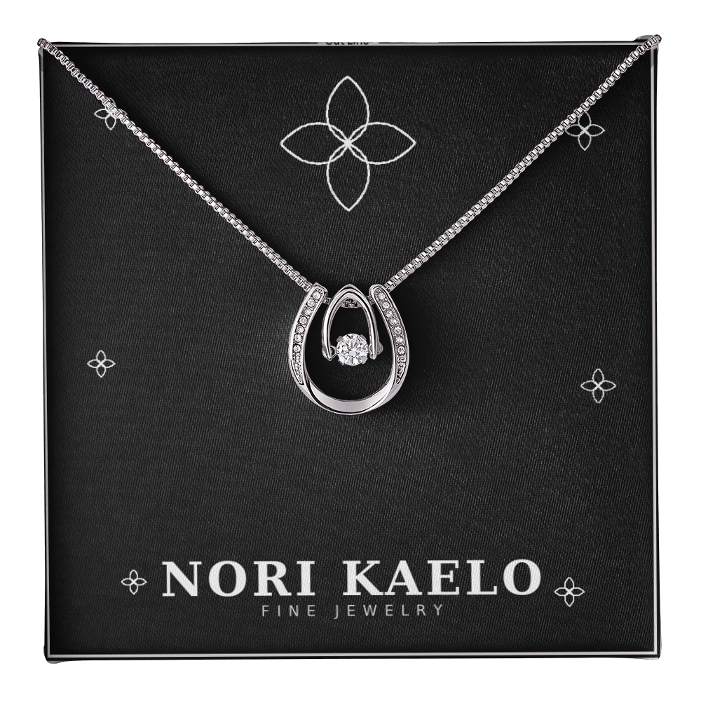Dancing stone pendant necklace in white gold, displayed on a black Nori Kaelo Fine Jewelry gift box.