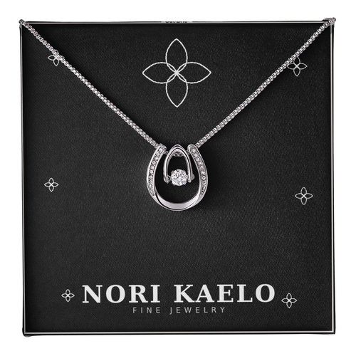 Dancing stone pendant necklace in white gold, displayed on a black Nori Kaelo Fine Jewelry gift box.
