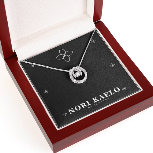Dancing stone pendant necklace in white gold, displayed in a mahogany-style luxury gift box.