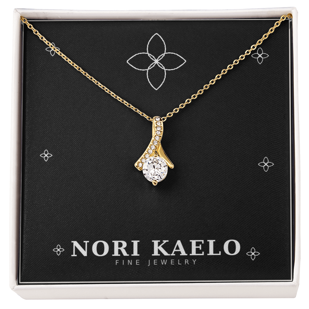 Ribbon pendant necklace in yellow gold, displayed on a black Nori Kaelo Fine Jewelry gift box.