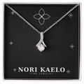 Ribbon pendant necklace in white gold, displayed on a black Nori Kaelo Fine Jewelry gift box.