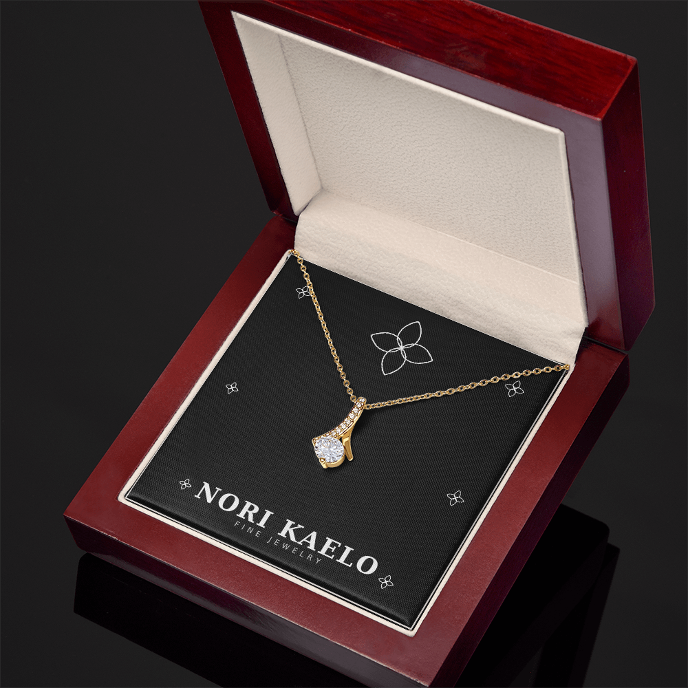 Ribbon pendant necklace in yellow gold, displayed in an open mahogany gift box.