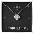 Love knot pendant necklace in white gold, displayed on a black Nori Kaelo Fine Jewelry gift box.
