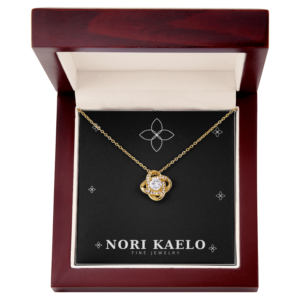 Love knot pendant necklace in yellow gold, displayed in an open mahogany gift box.