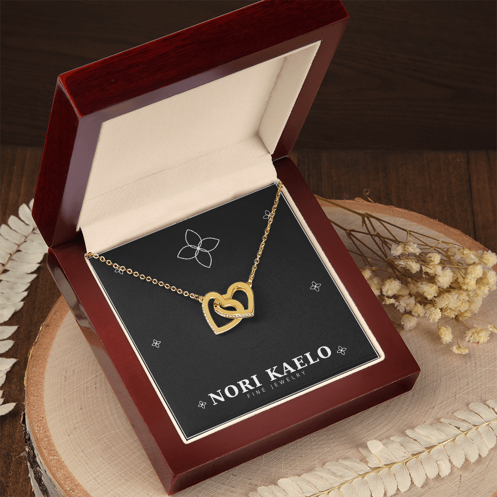 Interlocking hearts pendant necklace in yellow gold, displayed in an open mahogany gift box.