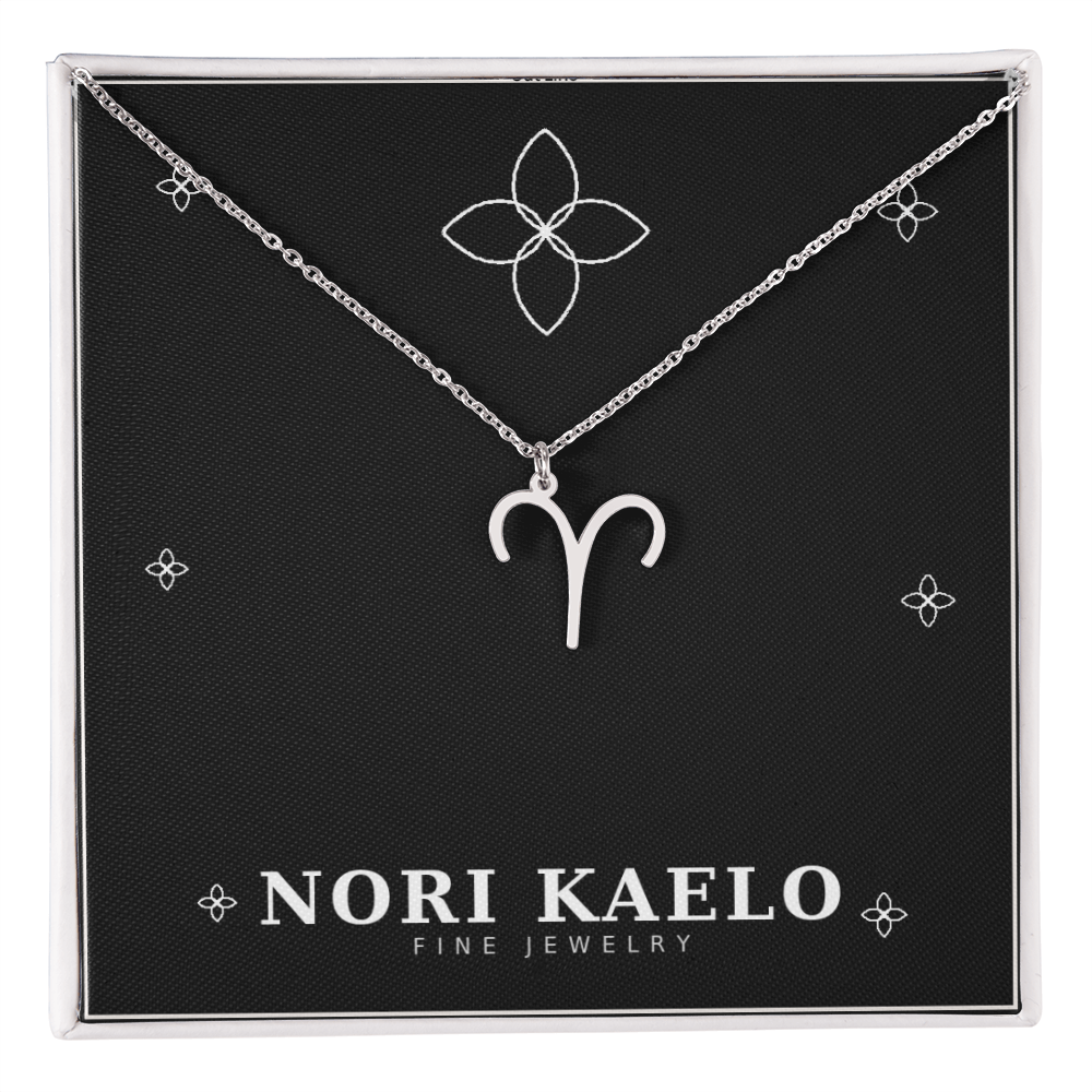 Zodiac Sign Necklace in stainless steel with Aries pendant, displayed on Nori Kaelo jewelry card.